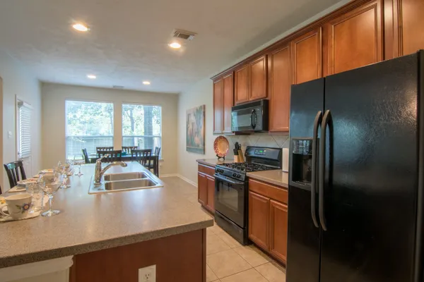 a kitchen with kitchen island granite countertop a sink stove and refrigerator