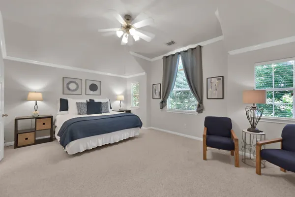 a spacious bedroom with a bed and a chair