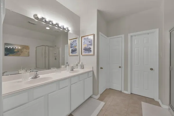 a spacious bathroom with a double vanity sink mirror and shower