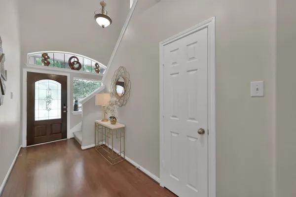 a view of a hallway with entryway wooden floor and front door