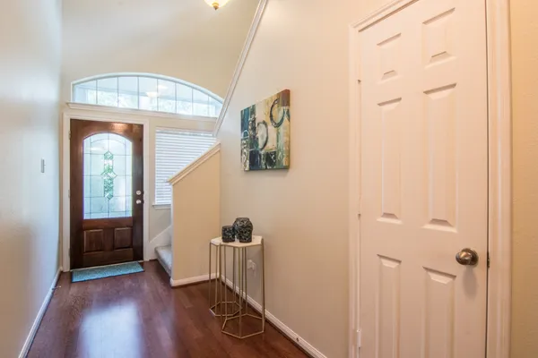 a view of a hallway with wooden floor and staircase