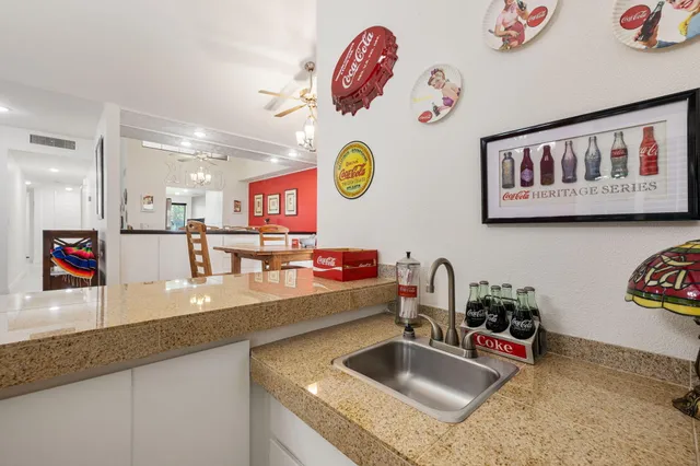 a view of a dining room with furniture and a chandelier fan