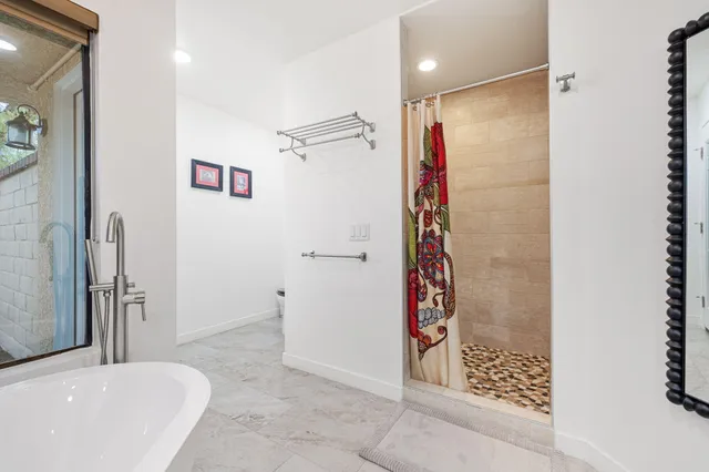 a spacious bathroom with a double vanity sink mirror and bathtub