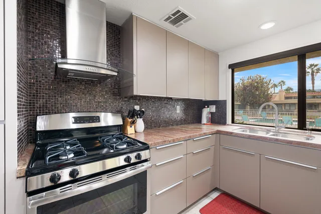 a kitchen with stainless steel appliances granite countertop a stove and a sink