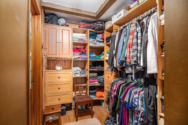a view of walk in closet with clothes and shoes