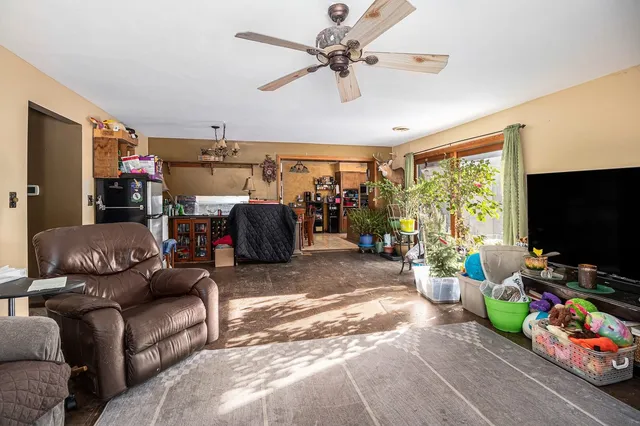 a living room with furniture a flat screen tv and a window