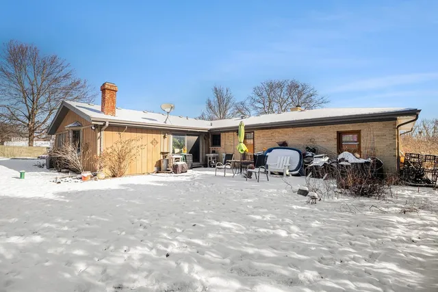 a view of a house with a yard covered in snow
