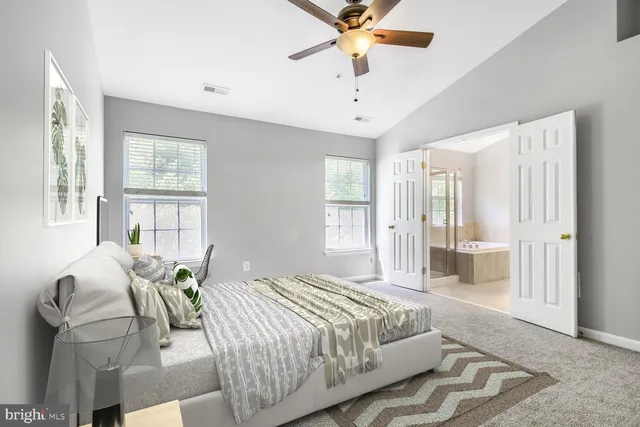 a spacious bedroom with a bed and glass window