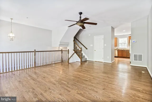 a view of a livingroom with wooden floor and a ceiling fan