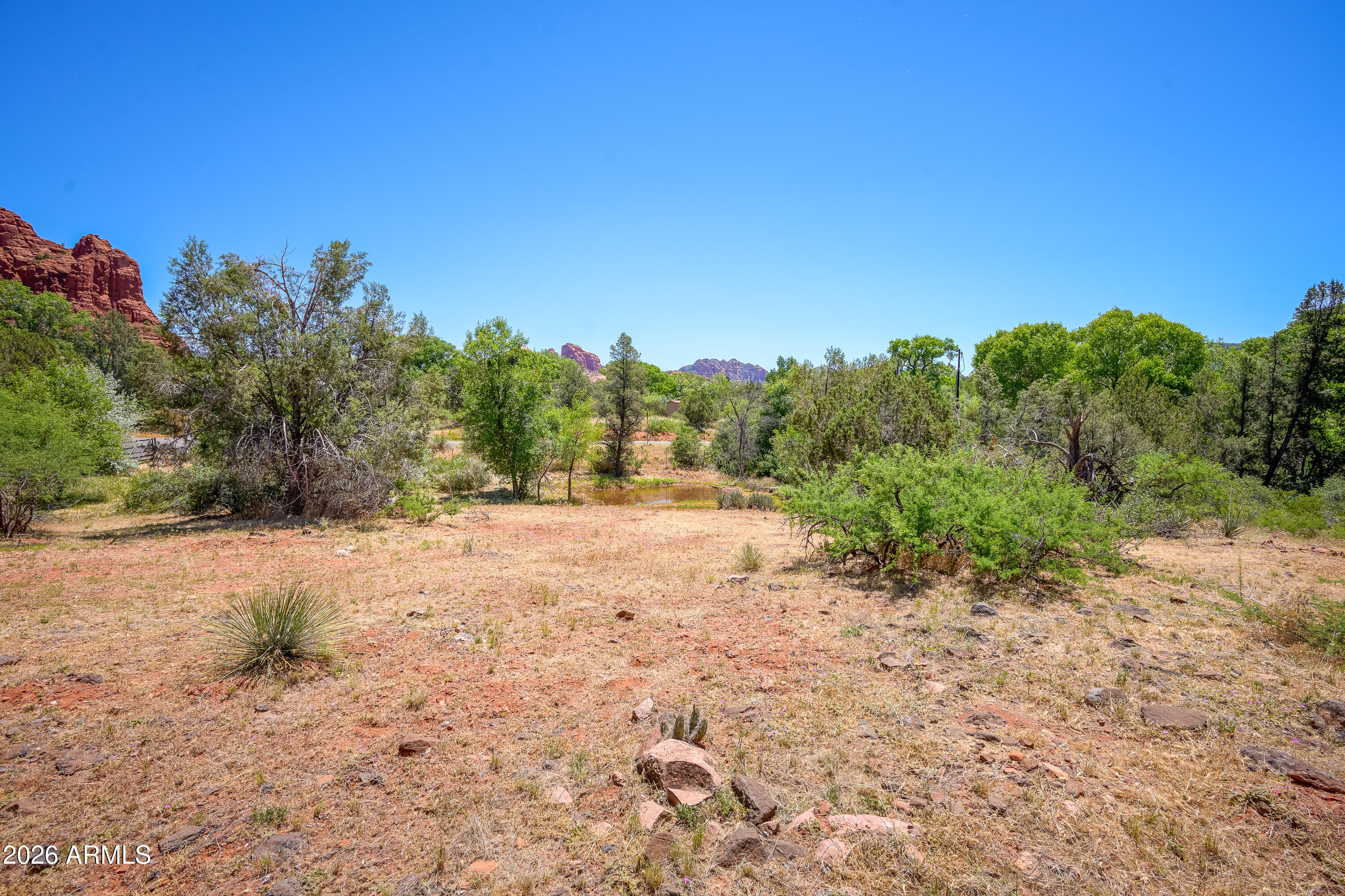 3155 Red Rock Loop Road, Unit 1 Sedona, AZ 86336 - Photo 13 of 18 a view of a dirt road with trees in the background