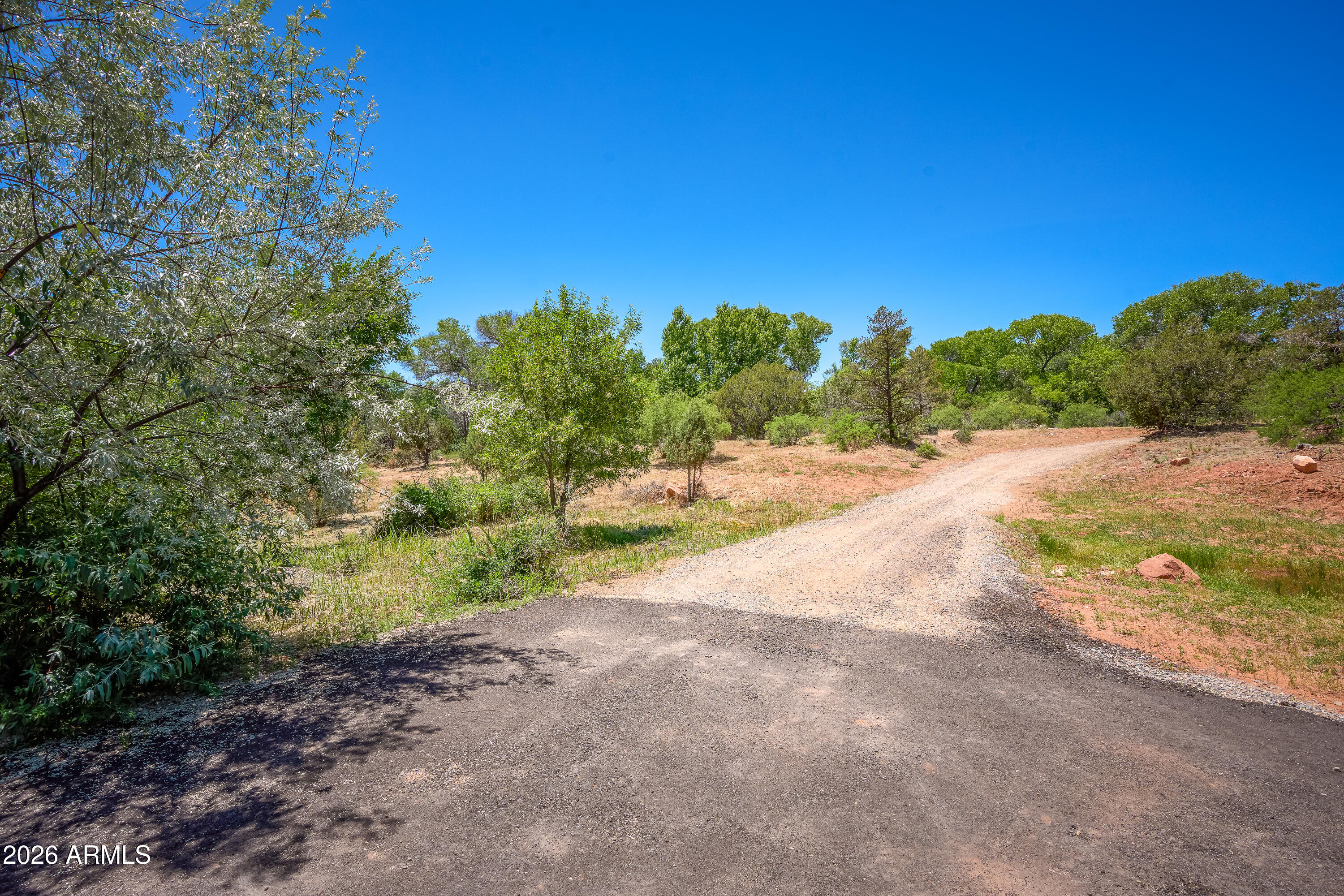 3155 Red Rock Loop Road, Unit 1 Sedona, AZ 86336 - Photo 18 of 18 a view of a dirt road with trees in the background