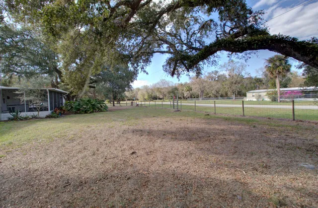 a view of a house with a yard and potted plants