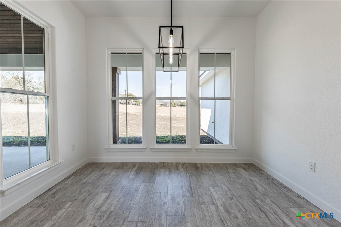 110 Lake Village Road Seguin, TX 78155 - Photo 11 of 38 an empty room with wooden floor and windows