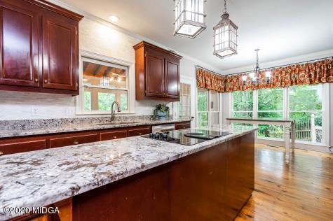 113 Hampton Ridge Road Macon, GA 31220 - Photo 13 of 29 a kitchen with granite countertop wooden cabinets a stove a oven and a large window