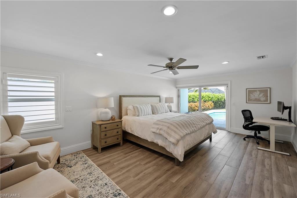 4611 Crayton Road Naples, FL 34103 - Photo 18 of 38 a bedroom with a bed and wooden floor