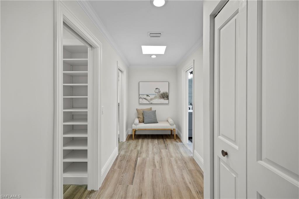 4611 Crayton Road Naples, FL 34103 - Photo 19 of 38 a view of a hallway view with wooden floor and a bathroom