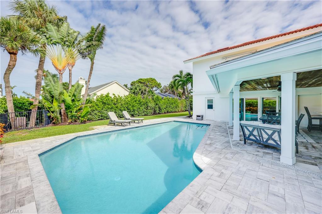 4611 Crayton Road Naples, FL 34103 - Photo 33 of 38 a view of a swimming pool with a patio
