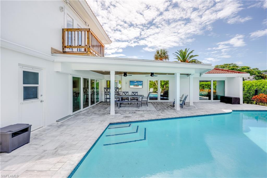 4611 Crayton Road Naples, FL 34103 - Photo 35 of 38 a view of house with swimming pool outdoor seating and barbeque oven