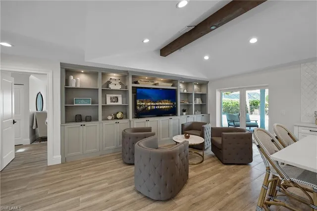 a living room with furniture a flat screen tv and wooden floor