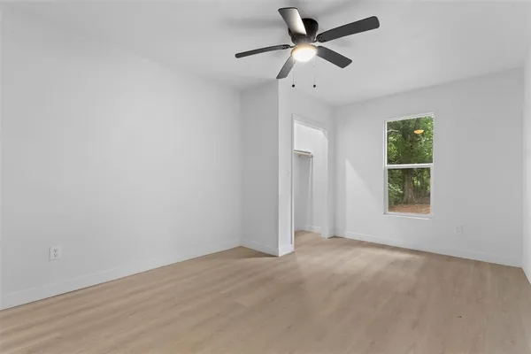 wooden floor in an empty room with a ceiling fan