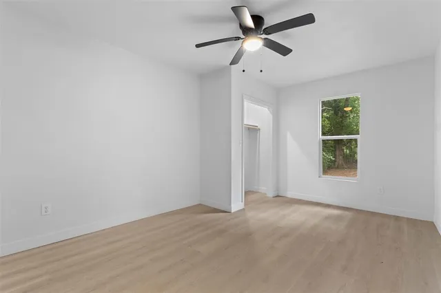 wooden floor in an empty room with a ceiling fan