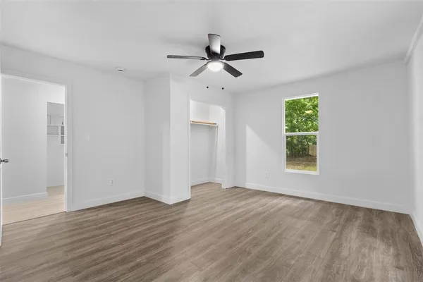 a view of room with window ceiling fan and hardwood floor