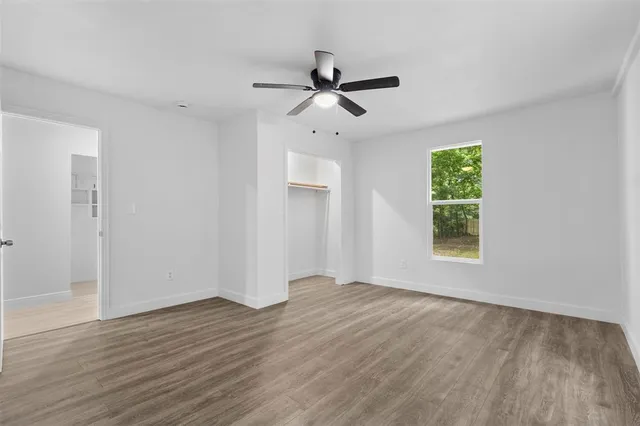 a view of room with window ceiling fan and hardwood floor