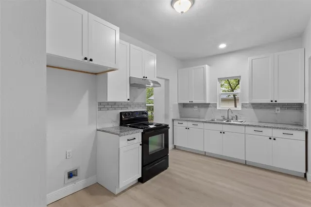 a kitchen with stainless steel appliances granite countertop a sink and a stove