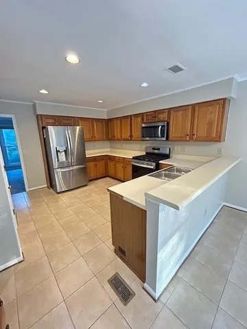 a kitchen with stainless steel appliances a stove a microwave a sink a counter top space and cabinets