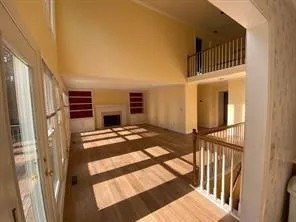 a view of a bedroom with wooden floor and a fireplace