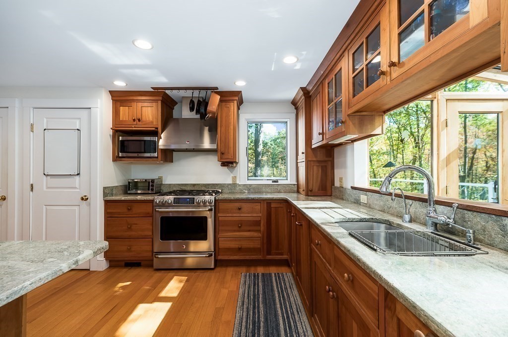 8 Mill Road Ipswich, MA 01938 - Photo 14 of 38 a kitchen with stainless steel appliances granite countertop a sink stove and refrigerator