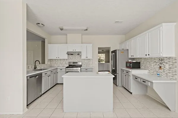 a kitchen with stainless steel appliances a stove refrigerator sink and cabinets