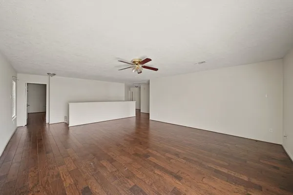 a view of a livingroom with wooden floor and a ceiling fan