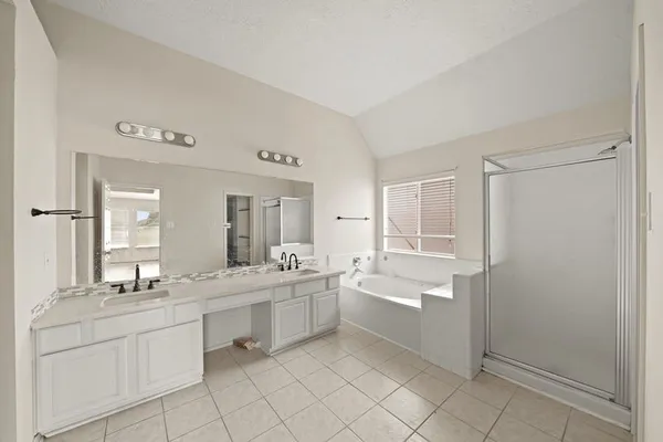 a large bathroom with a double vanity sink a mirror and a bathtub