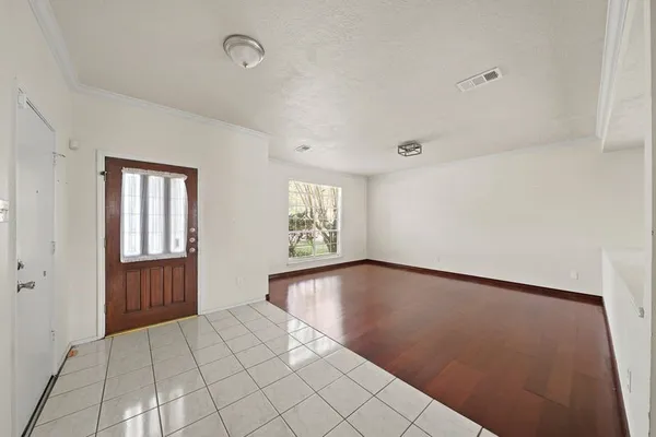 a view of an empty room with window and cabinet
