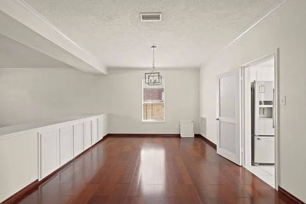 a hallway with wooden floor closet and windows
