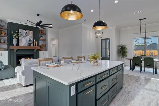 a view of a dining room and kitchen with a table chairs