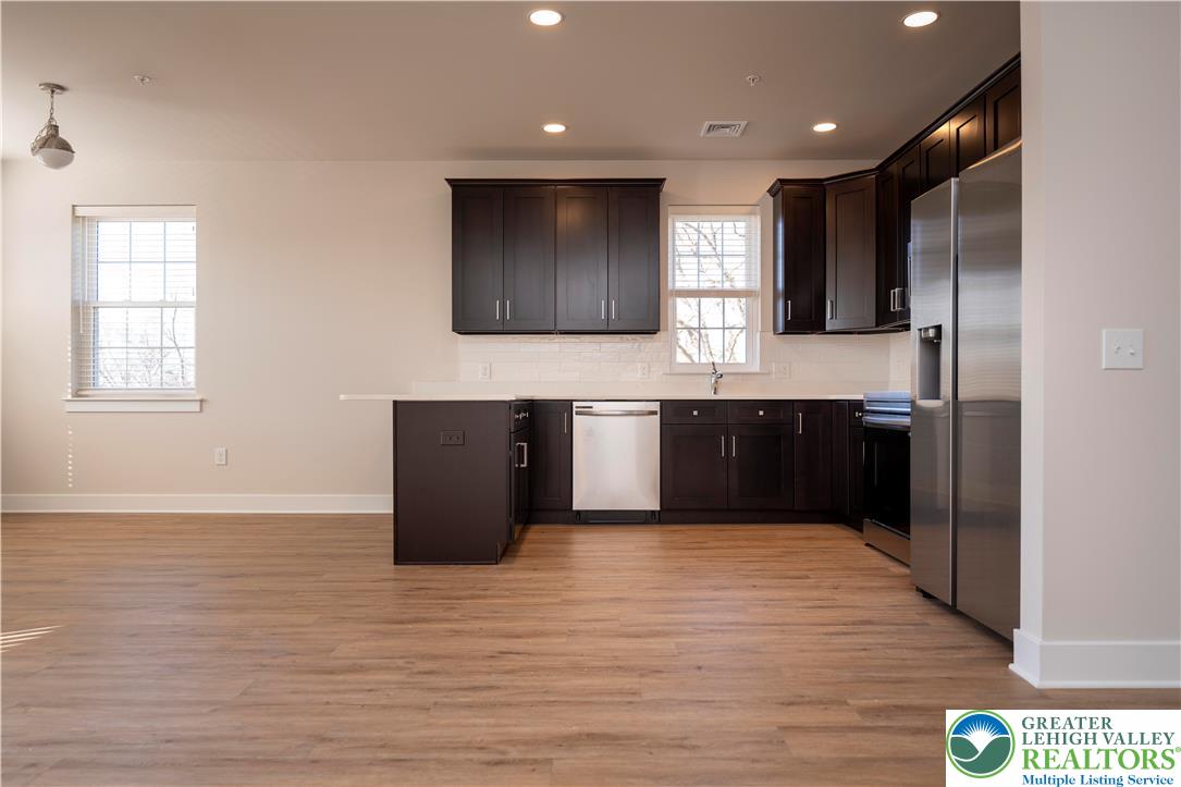 1763 Madison Avenue, Unit 201 Bethlehem, PA 18017 - Photo 8 of 20 a large kitchen with wooden cabinets and a wooden floor