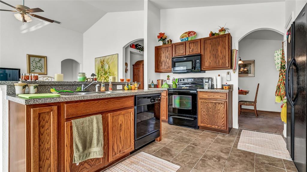 1153 Legatto Loop Dundee, FL 33838 - Photo 17 of 48 a kitchen with stainless steel appliances granite countertop a stove a sink and a refrigerator