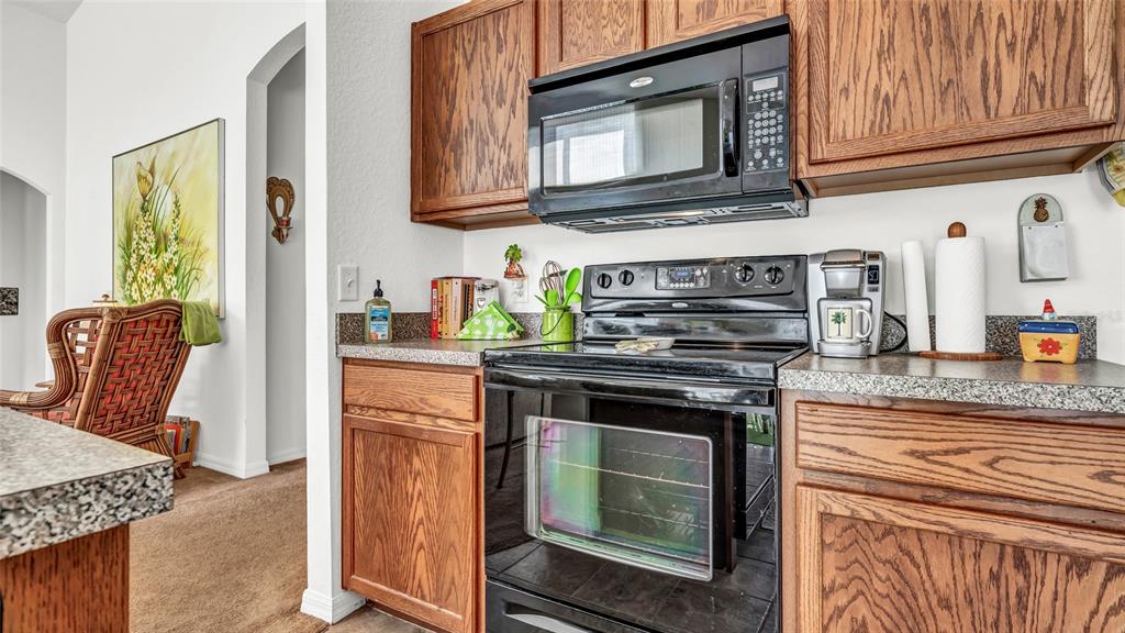 1153 Legatto Loop Dundee, FL 33838 - Photo 18 of 48 a kitchen with granite countertop a stove top oven microwave and cabinets