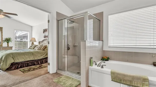 a en suite bathroom with a tub shower and window