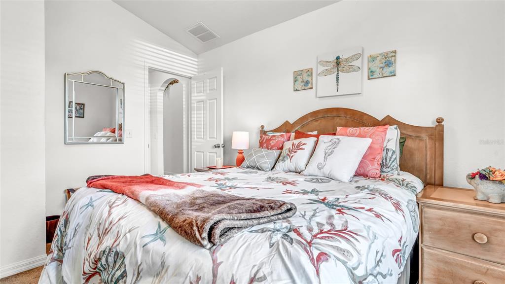 1153 Legatto Loop Dundee, FL 33838 - Photo 27 of 48 a bedroom with a bed and a lamp on dresser