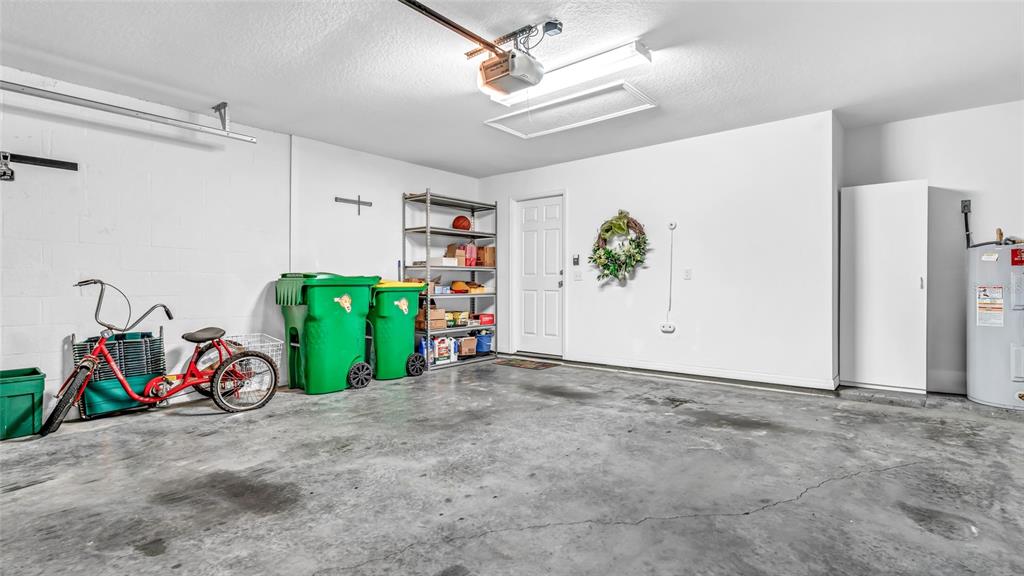 1153 Legatto Loop Dundee, FL 33838 - Photo 34 of 48 a view of a garage with a bike and white doors