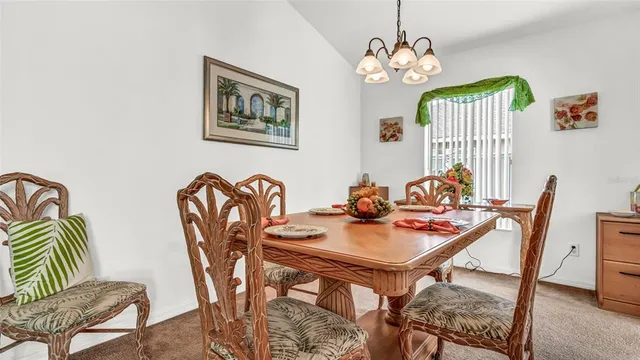 a view of a dining room with furniture a chandelier and wooden floor