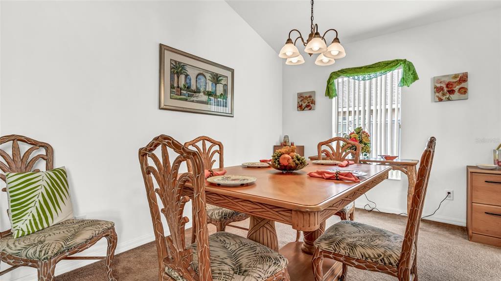 1153 Legatto Loop Dundee, FL 33838 - Photo 9 of 48 a view of a dining room with furniture a chandelier and wooden floor