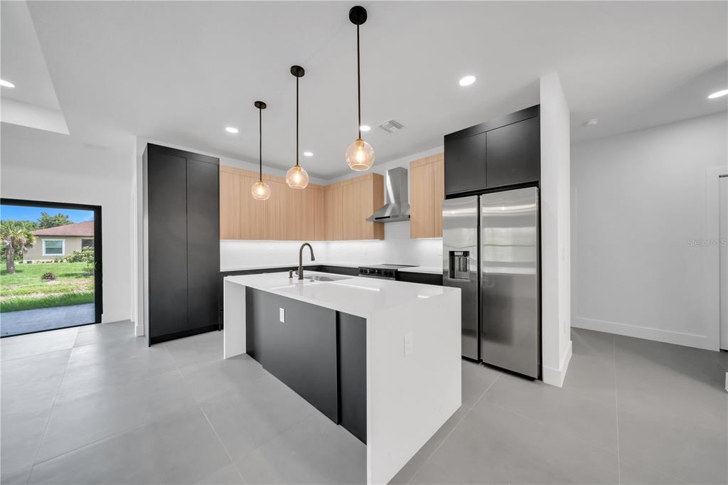 2328 Irondale Road North Port, FL 34287 - Photo 9 of 45 a kitchen with stainless steel appliances granite countertop a refrigerator a sink a stove and a wooden floors