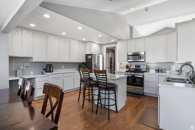 13176 Day Court Draper, UT 84020 - Photo 8 of 45 Kitchen with stainless steel appliances, lofted ceiling, a breakfast bar area, light countertops, and white cabinetry