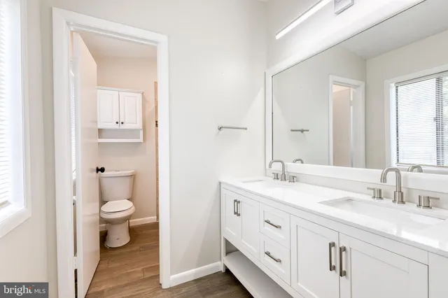 a spacious bathroom with a toilet sink and a mirror