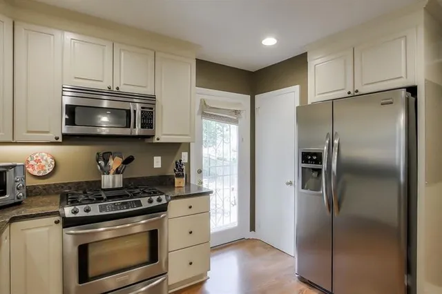 a kitchen with stainless steel appliances granite countertop a stove a refrigerator and a microwave
