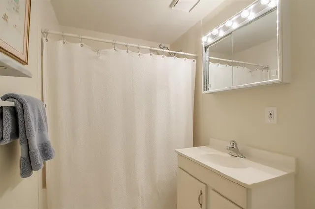 a bathroom with a sink a mirror and a shower